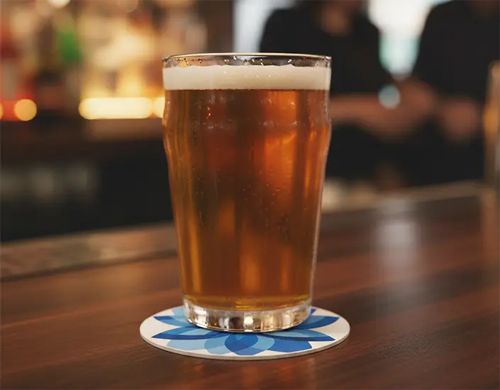 A glass of beer on a coaster