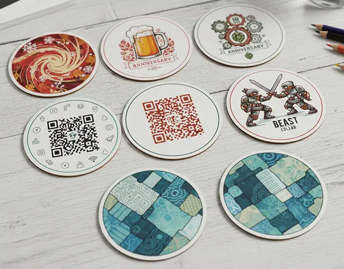 Assorted custom printed coasters featuring artwork, QR codes, and limited edition designs.
