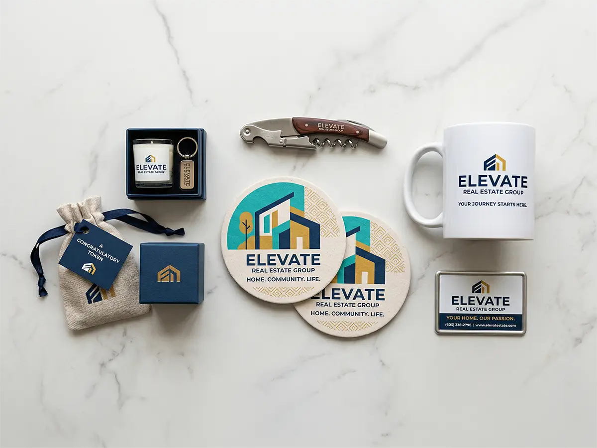 Real estate promotional items including custom coasters, mug, keychain, and closing gift set on marble surface