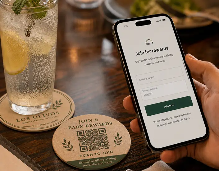 Guest scans a QR code coaster with a smartphone to join a restaurant rewards and email signup program.