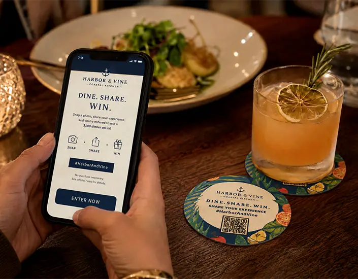 Guest scans a QR code on a Harbor & Vine restaurant coaster for a dine, share, and win social media promotion.