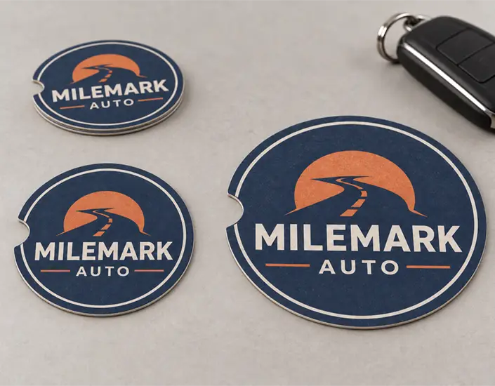 Milemark Auto pulpboard car coasters in different sizes, with finger notches, beside a car key fob.